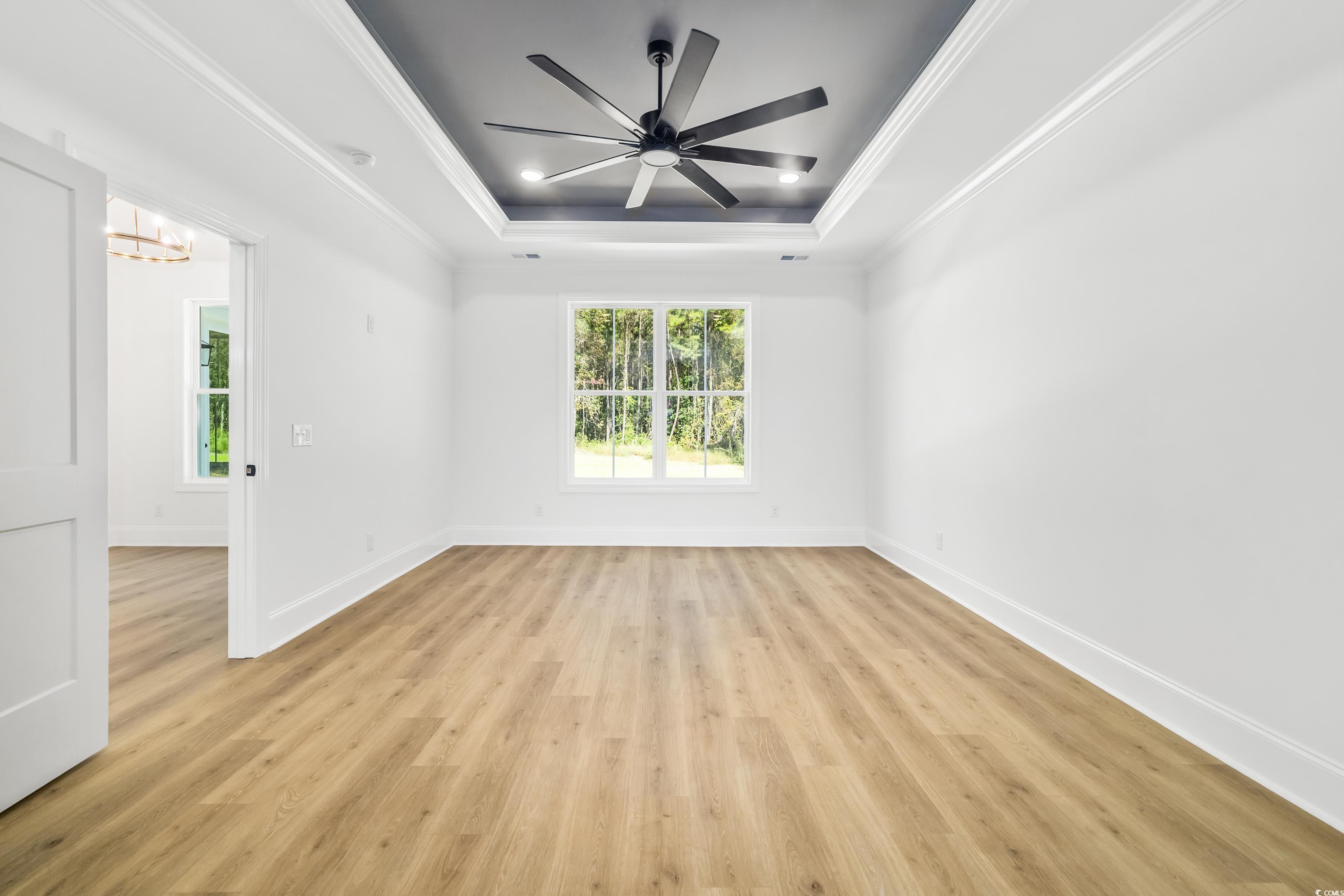 346 Ridge Road Galivants Ferry, SC 29544 - Photo 19 of 28 Spare room featuring crown molding, a tray ceiling, light wood-style floors, a chandelier, and a ceiling fan