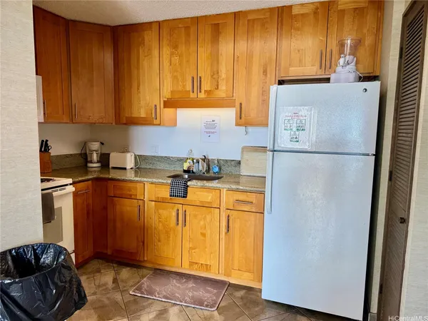 a kitchen with stainless steel appliances granite countertop a refrigerator a sink dishwasher with a stove top oven