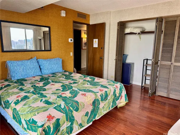 a bedroom with a bed and wooden floor