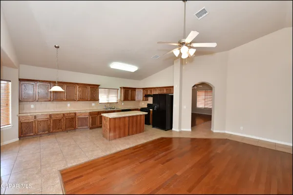 a view of a room with a chandelier fan and wooden floor
