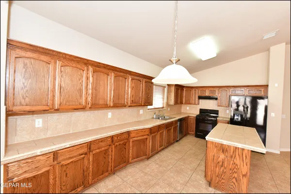 a kitchen with a stove a sink a microwave and a refrigerator