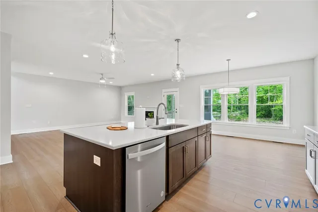 a kitchen with a sink a counter top space and living room view