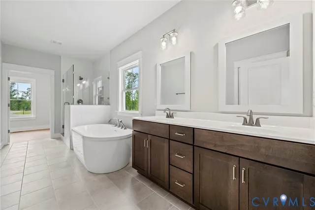 a spacious bathroom with a double vanity sink mirror and bathtub