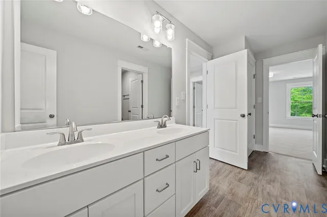a bathroom with a double vanity sink and mirror with shower