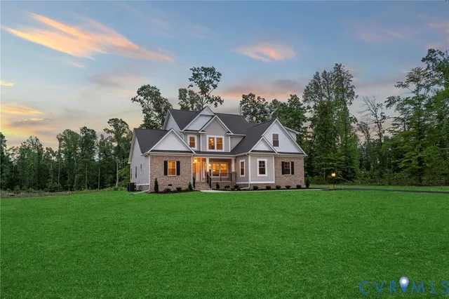 a front view of a house with a yard and trees