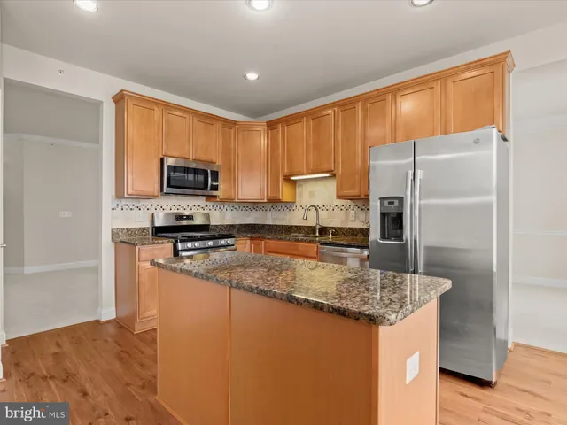 a kitchen with granite countertop a sink stove and microwave