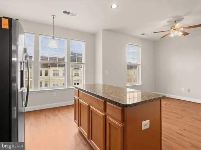 a kitchen with stainless steel appliances granite countertop a refrigerator a stove a sink a microwave and island