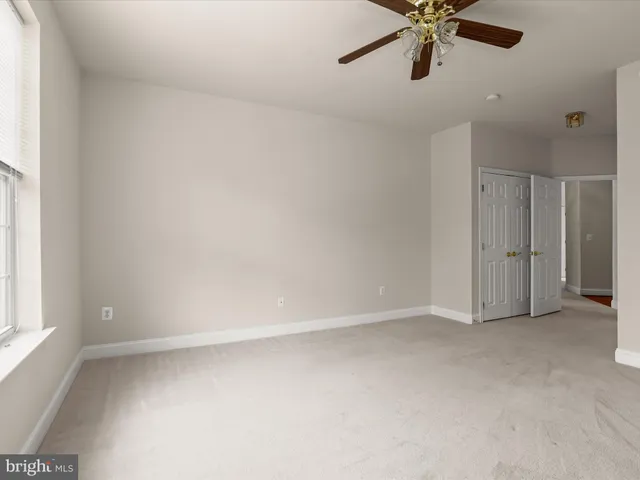 an empty room with a window and a fan