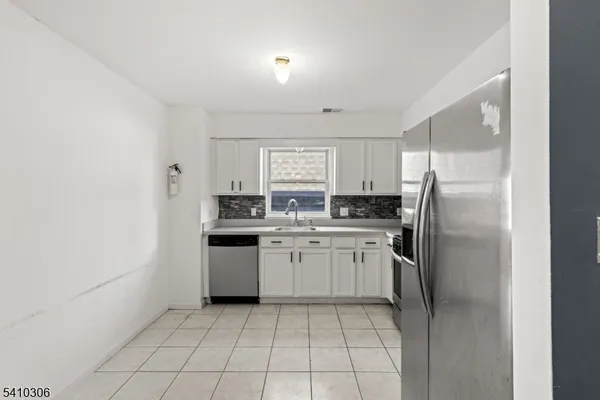 a kitchen with a refrigerator sink and cabinets