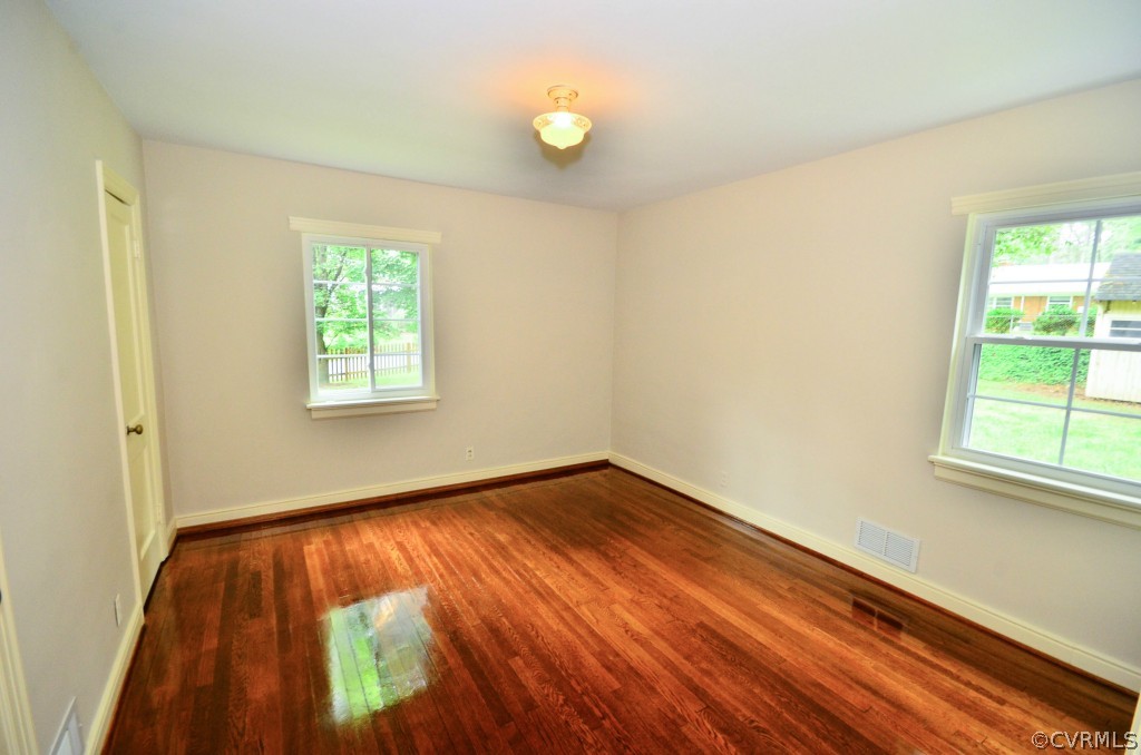 7501 Tanglewood Road Richmond, VA 23225 - Photo 9 of 19 a view of an empty room with wooden floor and a window
