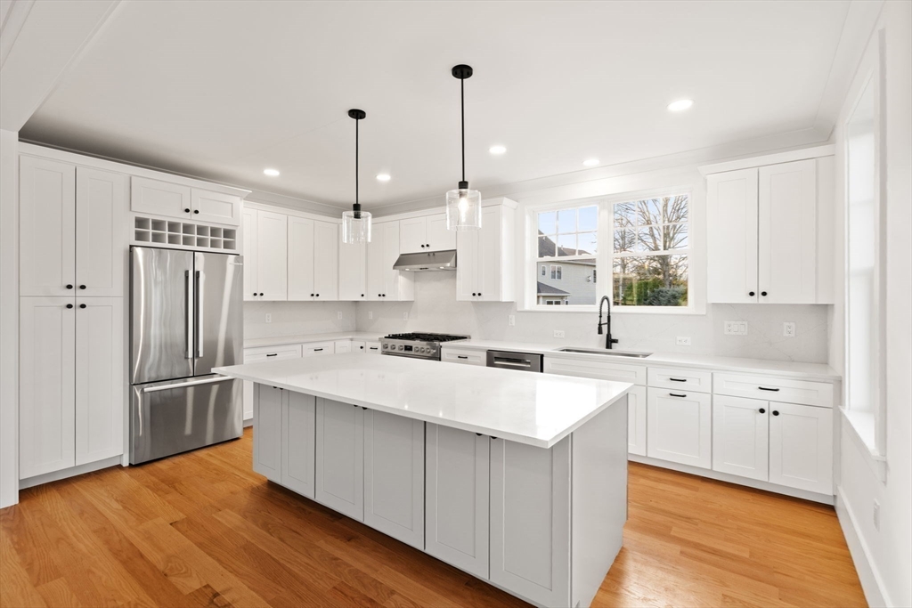 23 A Ward Street, Unit A Woburn, MA 01801 - Photo 12 of 42 a kitchen with white cabinets and stainless steel appliances