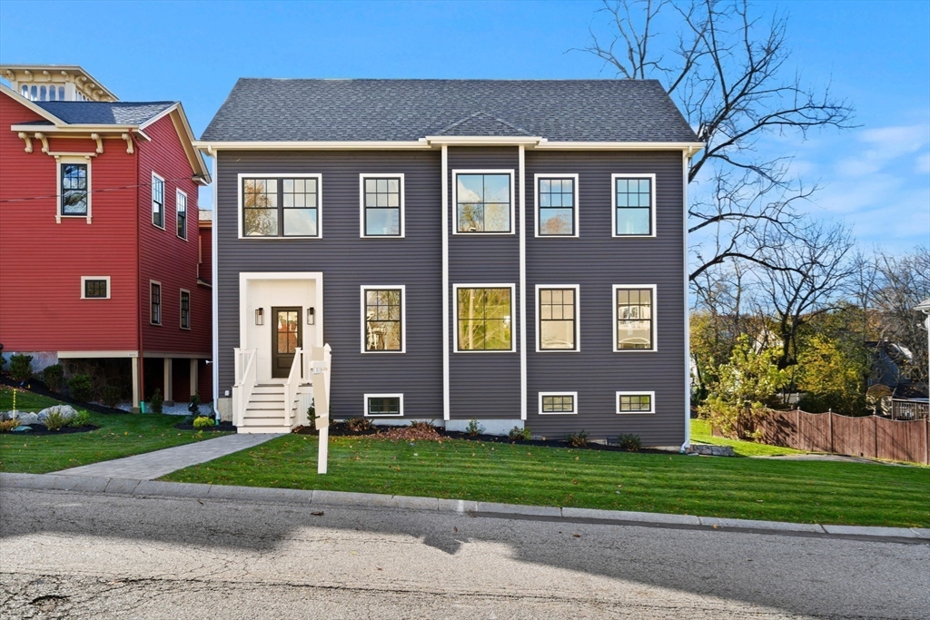 23 A Ward Street, Unit A Woburn, MA 01801 - Photo 3 of 42 a front view of a house with a garden and plants