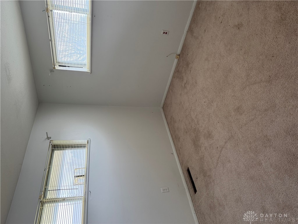 4867 Rittenhouse Drive Dayton, OH 45424 - Photo 4 of 17 Bright windows illuminate this cozy room, featuring comfortable carpet flooring for a welcoming atmosphere.