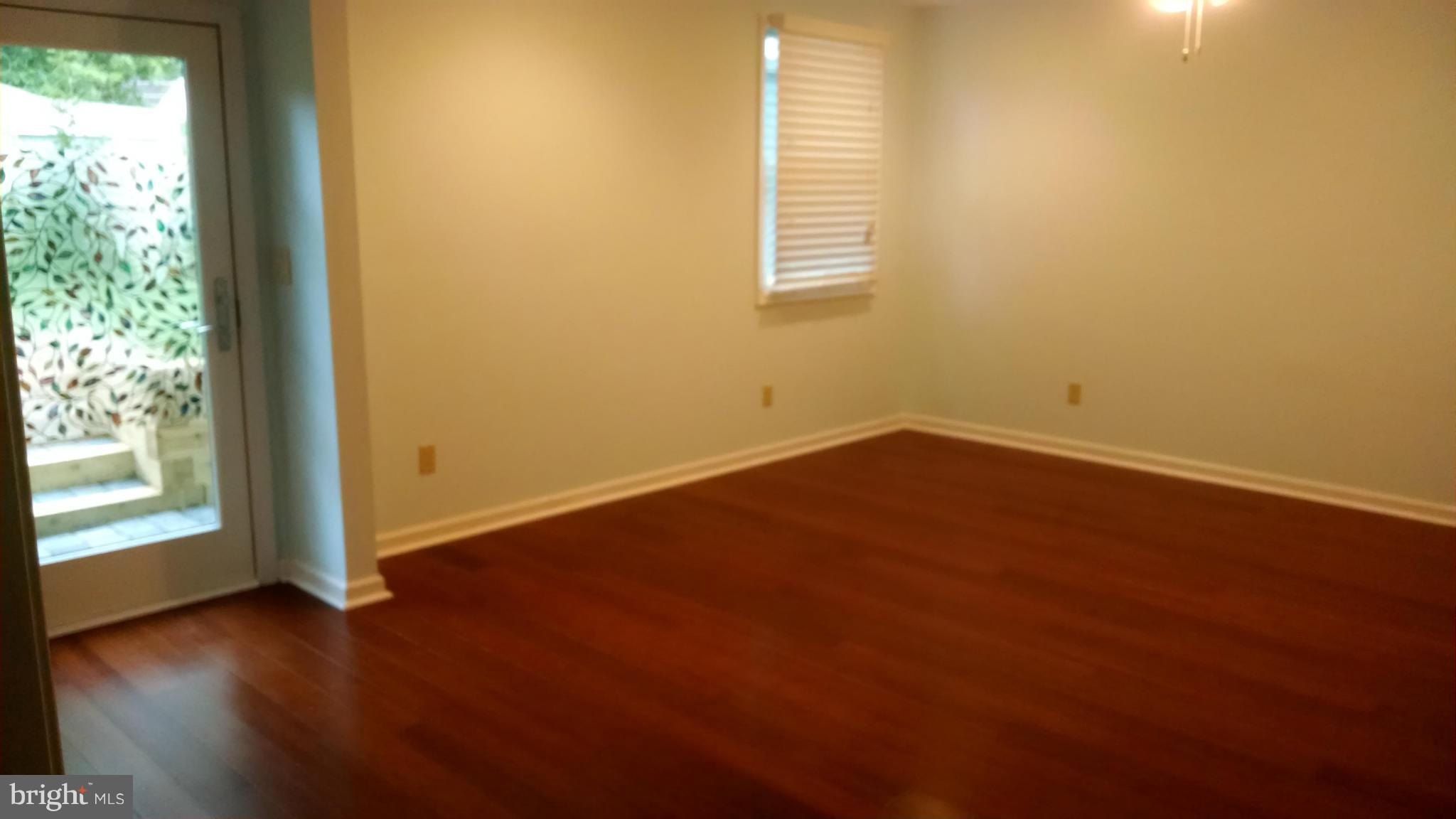 15 McKay Circle Cabin John, MD 20818 - Photo 11 of 20 an empty room with wooden floor and windows