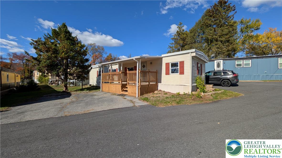 a view of a house with a yard and large tree