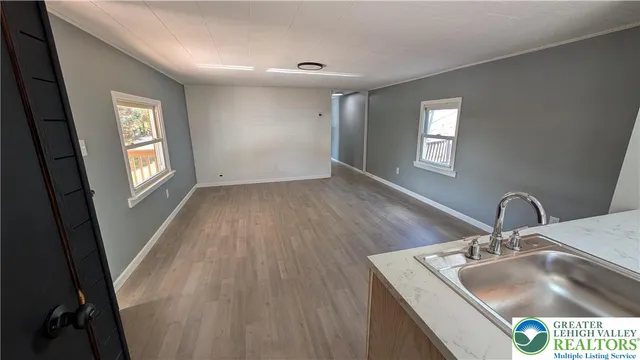 a kitchen with a sink a faucet a window and wooden floor