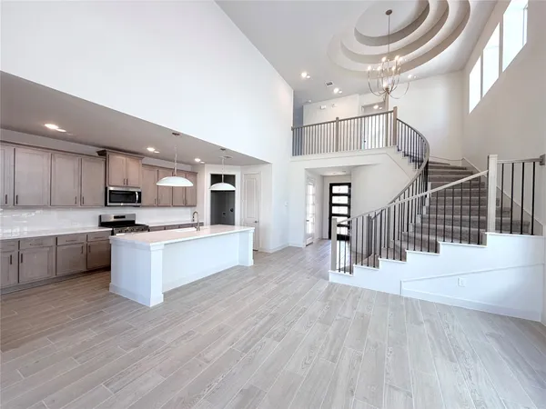 a large kitchen with cabinets wooden floor and stainless steel appliances