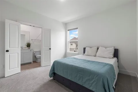 a spacious bedroom with a bed and a refrigerator