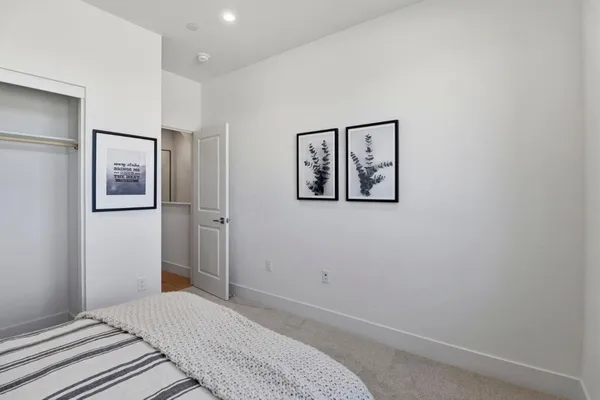 a bedroom with a bed and painting on the wall