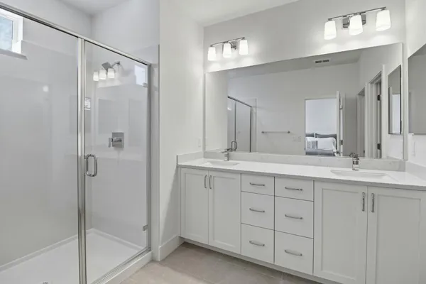 a bathroom with a double vanity sink mirror and shower