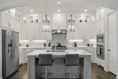 a kitchen with stainless steel appliances granite countertop a stove refrigerator sink and cabinets
