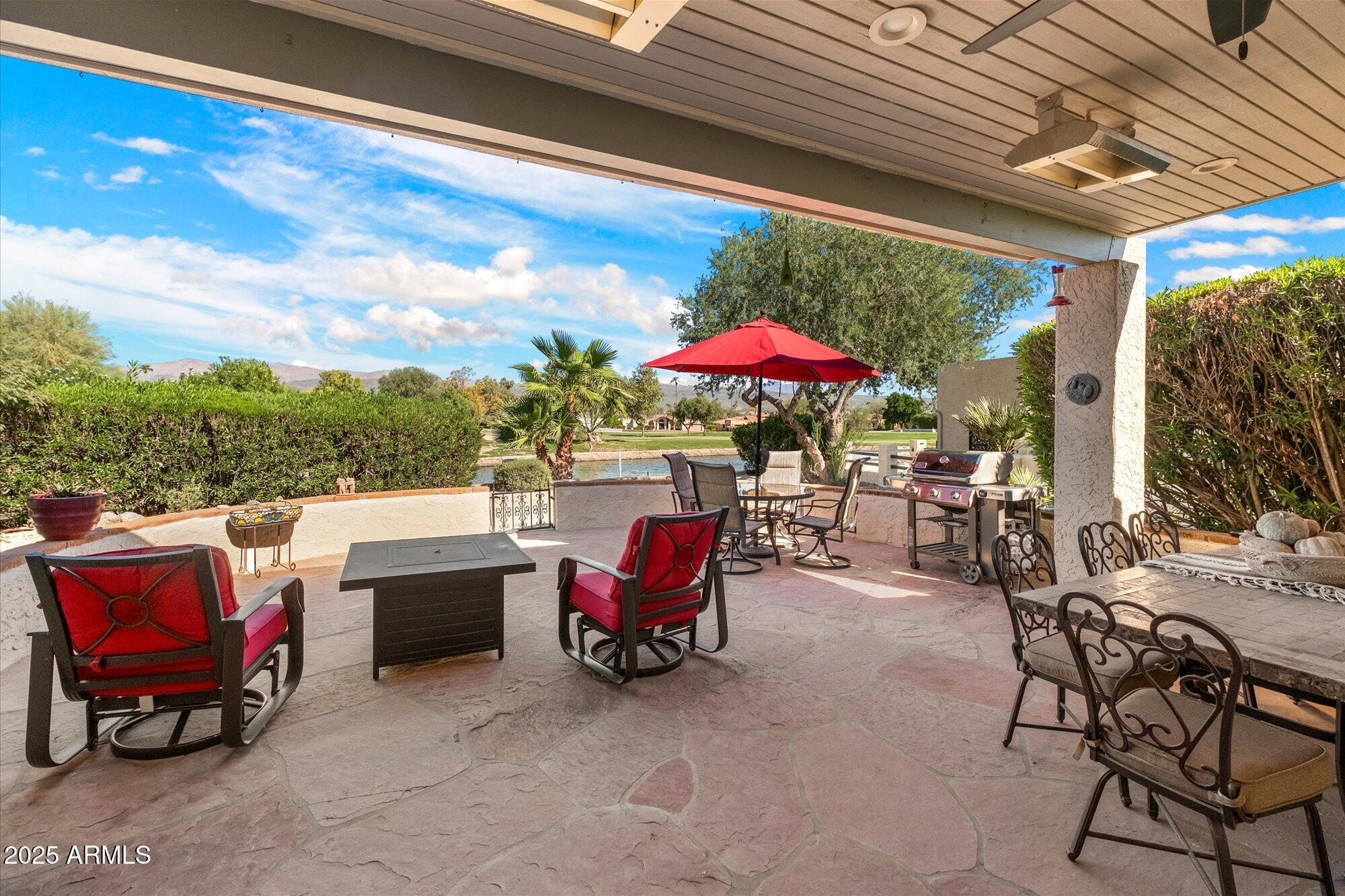 18720 East Vía Laguna Rio Verde, AZ 85263 - Photo 3 of 37 a patio with tables and chairs and a umbrella