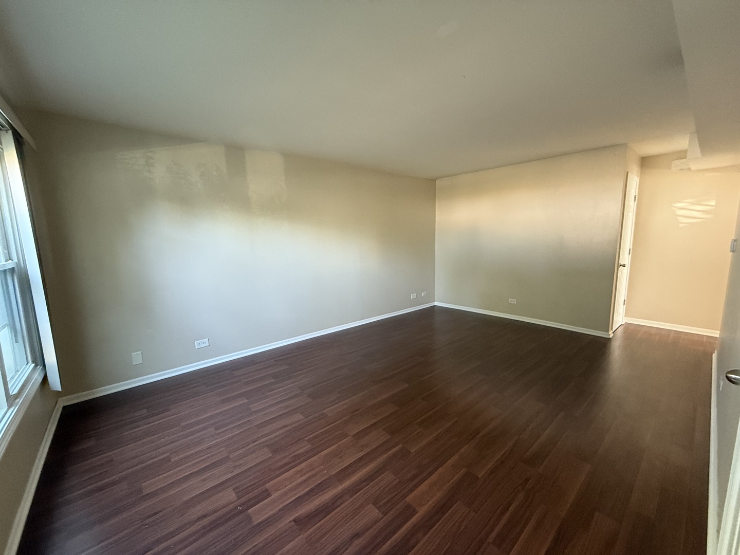 109 Central Avenue, Unit A Roselle, IL 60172 - Photo 2 of 11 an empty room with wooden floor and windows