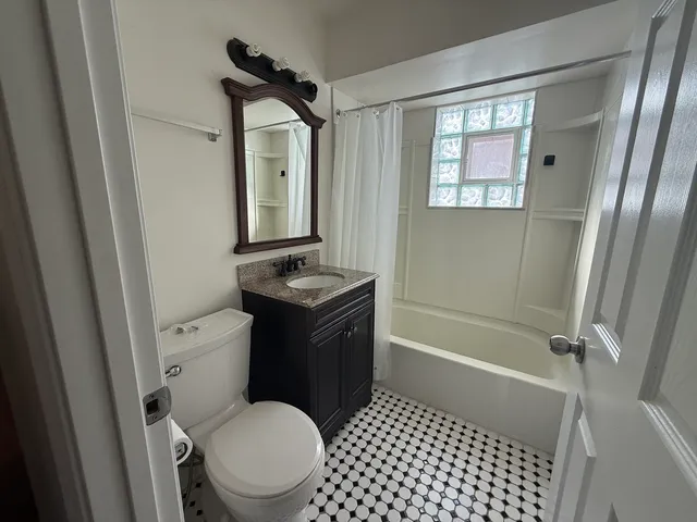 a bathroom with a granite countertop toilet sink and shower
