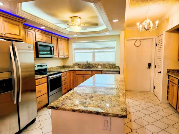 a kitchen with stainless steel appliances granite countertop a refrigerator a stove and a sink