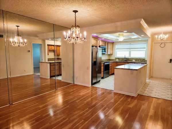 a view of a kitchen with stainless steel appliances granite countertop a oven and a wooden floors
