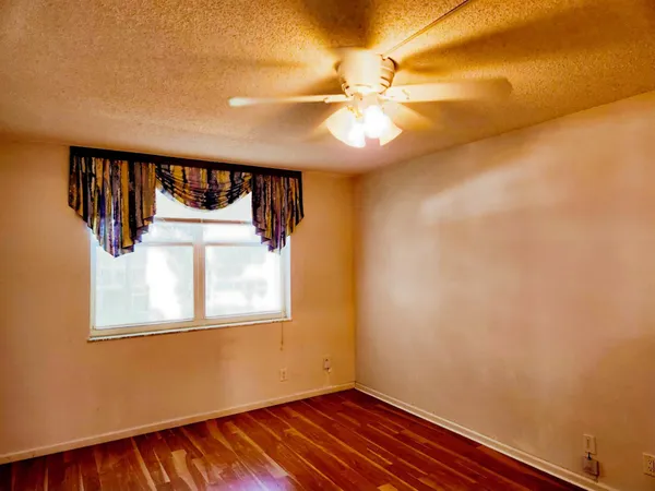 a view of a room with wooden floor and fan