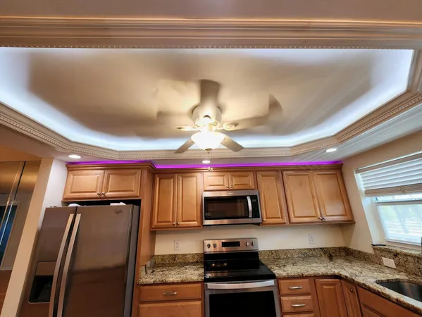 a kitchen with stainless steel appliances granite countertop a refrigerator a stove and a sink