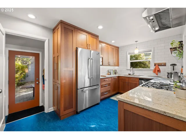 a kitchen with kitchen island wooden floors appliances and cabinets