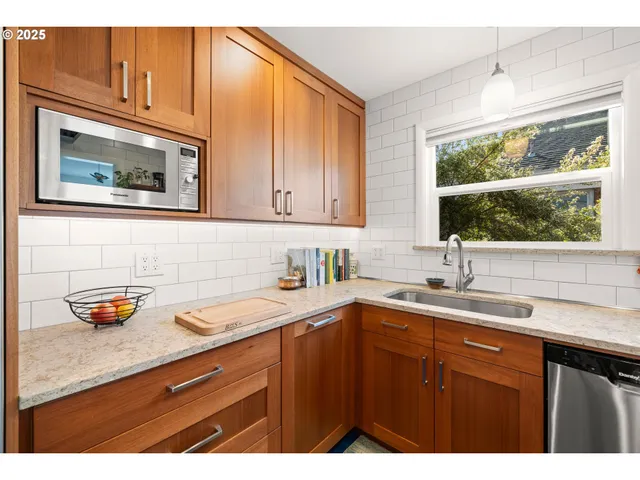 a kitchen with a sink a window and cabinets