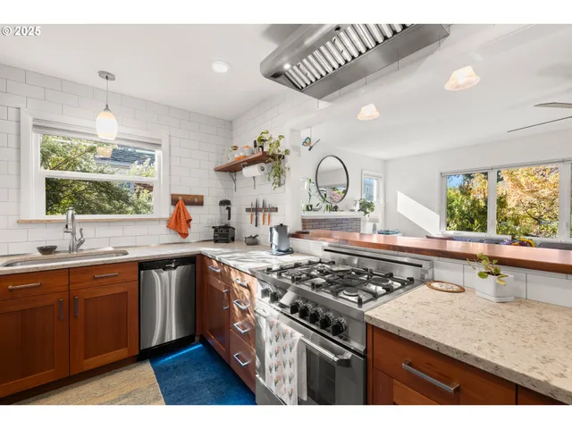 a kitchen with a stove a sink and a window