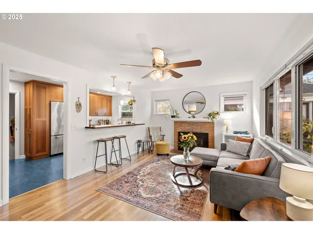 a living room with furniture a fireplace and a large window