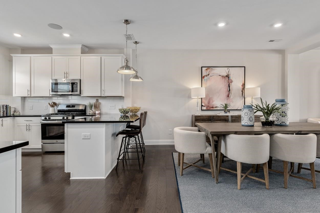 1002 Royal Mill Avenue Wake Forest, NC 27587 - Photo 7 of 51 a kitchen with kitchen island granite countertop a sink and white appliances