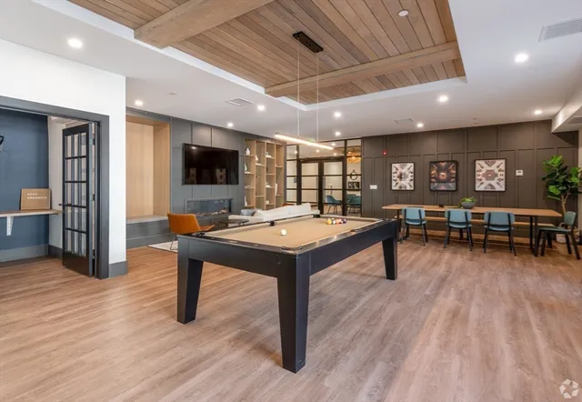 a living room with furniture pool table and a flat screen tv