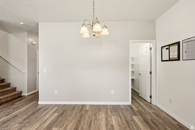 1177 Northfield Road, Unit 26 Cedar City, UT 84721 - Photo 14 of 45 Open-concept area featuring wood-finish flooring, a contemporary chandelier, a pantry with shelving, white baseboards, and a neutral wall color