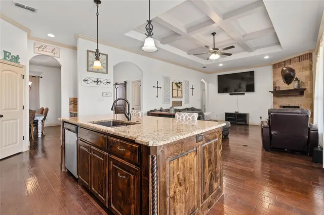 a kitchen with stainless steel appliances granite countertop a sink a stove and a wooden floors