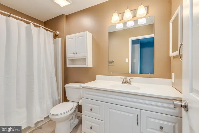 a bathroom with a sink vanity mirror and toilet