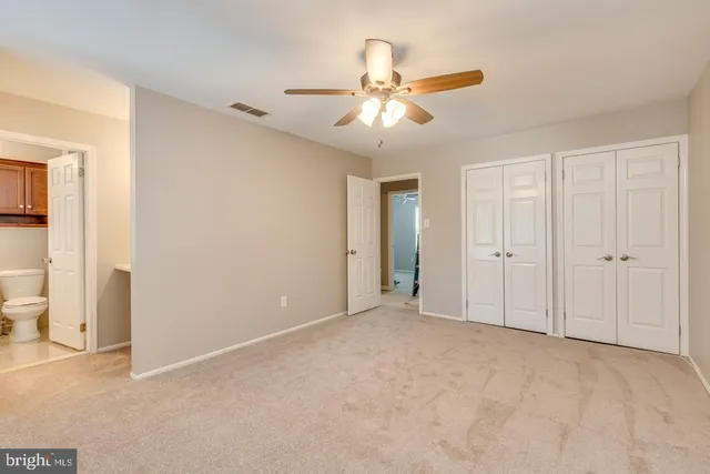 a view of an empty room and chandelier fan