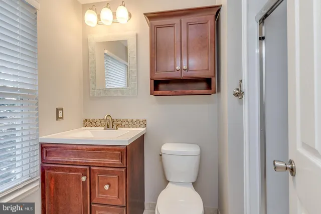 a bathroom with a toilet a sink and mirror
