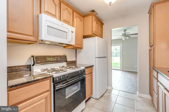 a kitchen with stainless steel appliances granite countertop a stove a refrigerator and a cabinets