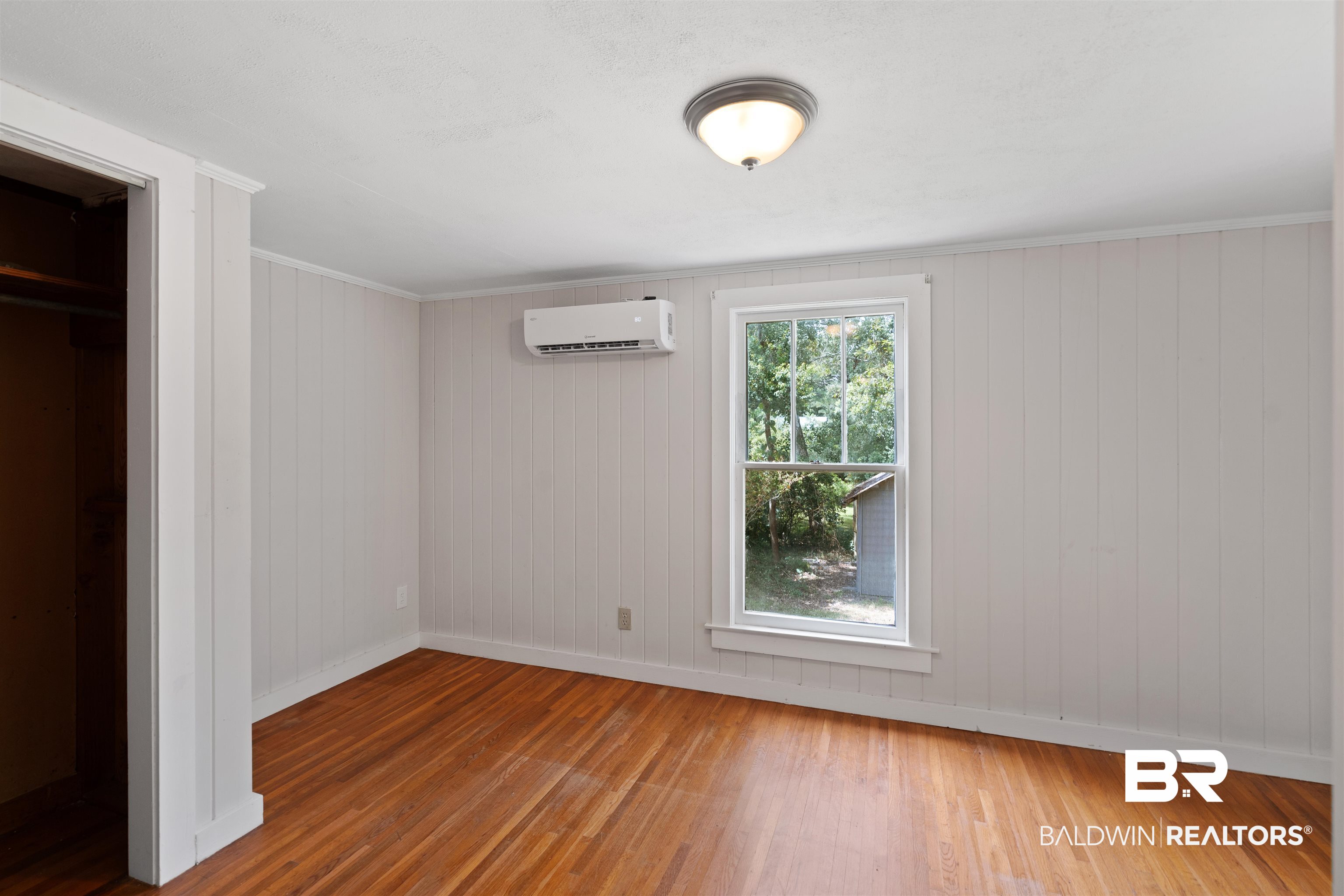2126 Barron Place Mobile, AL 36605 - Photo 20 of 33 Unfurnished bedroom with a wall mounted AC and wood-type flooring