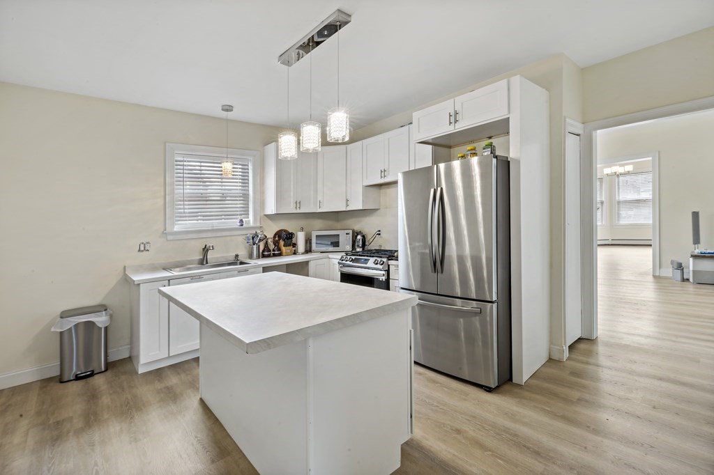 69 Locust Street New Bedford, MA 02740 - Photo 14 of 40 a kitchen with kitchen island a counter top space a sink appliances and cabinets