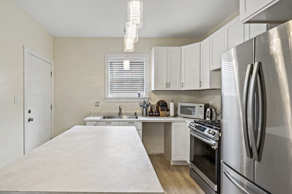 69 Locust Street New Bedford, MA 02740 - Photo 16 of 40 a kitchen with stainless steel appliances a refrigerator sink and stove