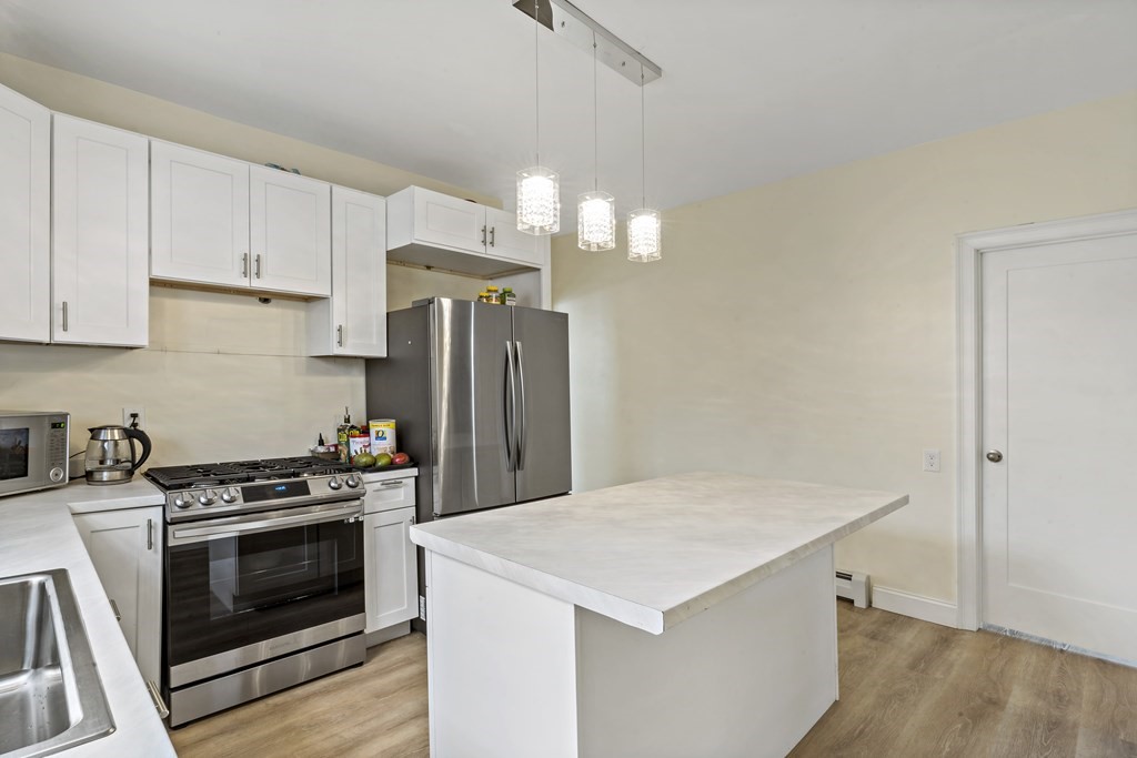 69 Locust Street New Bedford, MA 02740 - Photo 17 of 40 a kitchen with a stove a refrigerator and a sink
