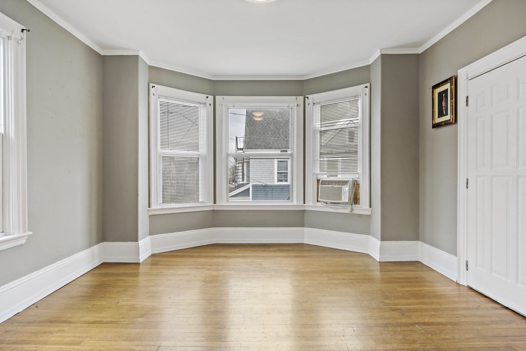 69 Locust Street New Bedford, MA 02740 - Photo 20 of 40 a view of an empty room with wooden floor and a window