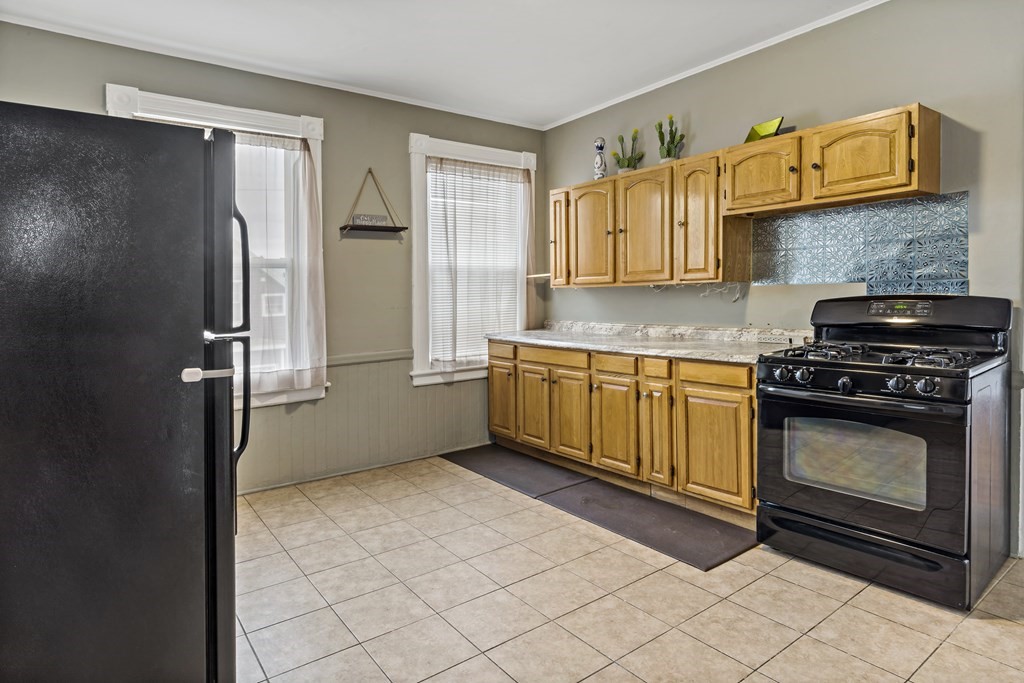 69 Locust Street New Bedford, MA 02740 - Photo 26 of 40 a kitchen with stainless steel appliances a refrigerator and a stove top oven